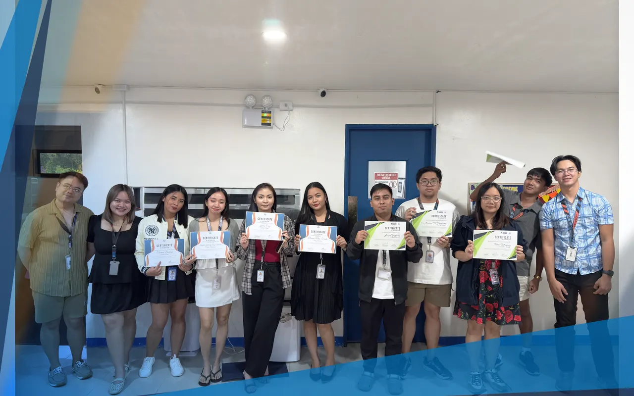 Thirteen team members holding certificates of recognition in the office